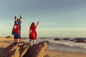 Boy And Girl Dressed As Superheroes On California Beach