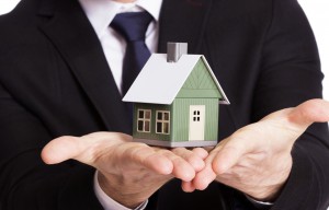 Real Estate Agent Holding A Model House