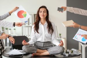Businesswoman With A Lot Of Work To Do Meditating In Office